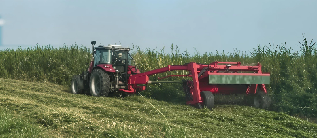 Heavy duty hay mower conditioner running through a thick alfalfa field