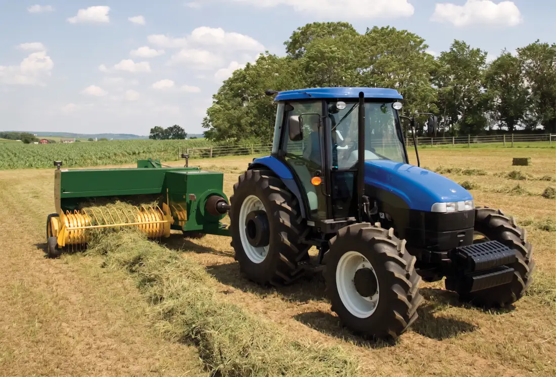 Square baler working in a field producing high density bales