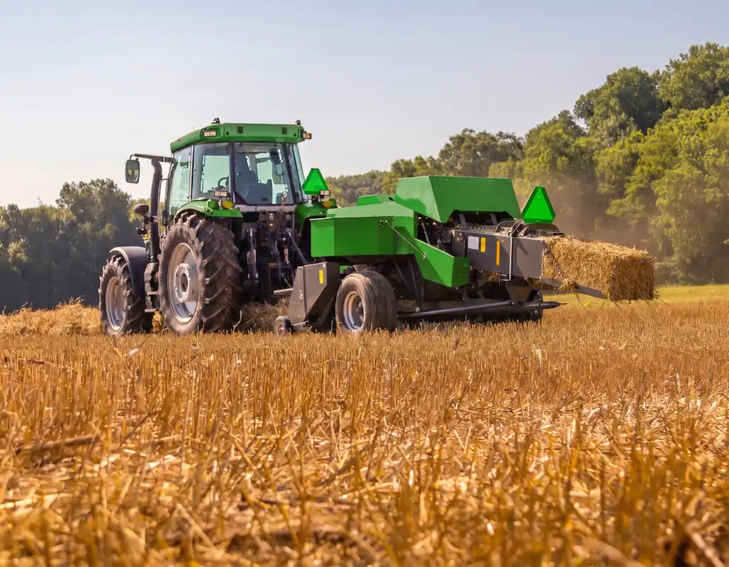 Square baler operating in a hay field